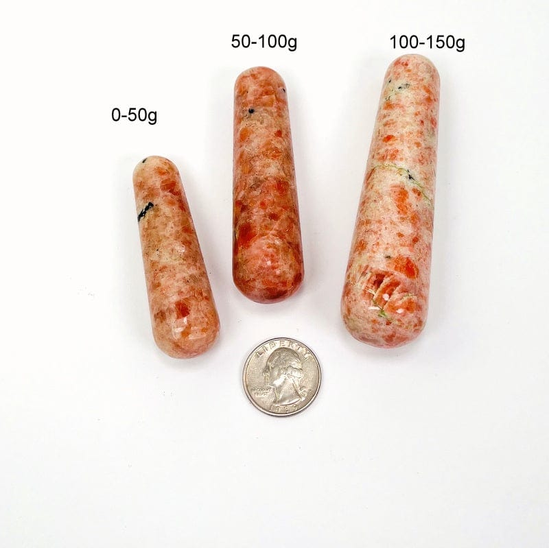 sunstone massage wands next to a quarter for size reference and the weight in grams 