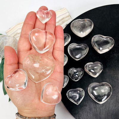 multiple crystal quartz hearts in hand displaying different sizes available 