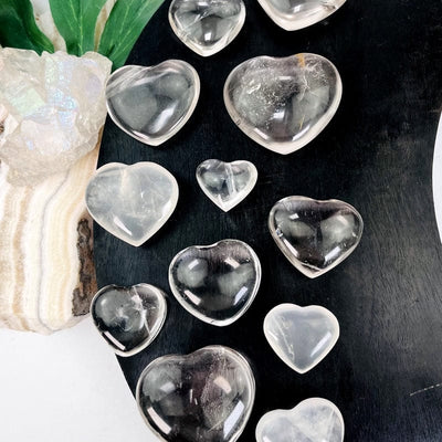 close up of multiple crystal quartz hearts showing different size options 