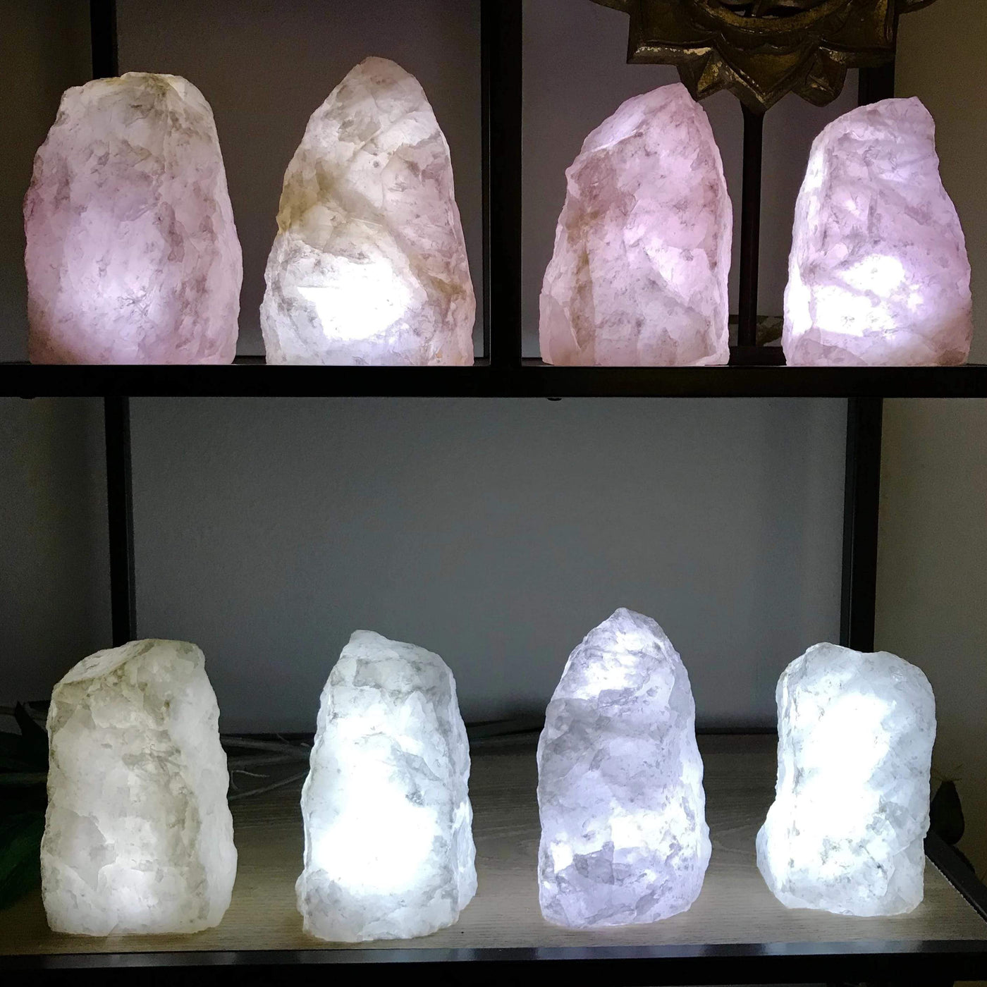 8 Rough Stone Lamps in groups of 4 lit up in a dark room