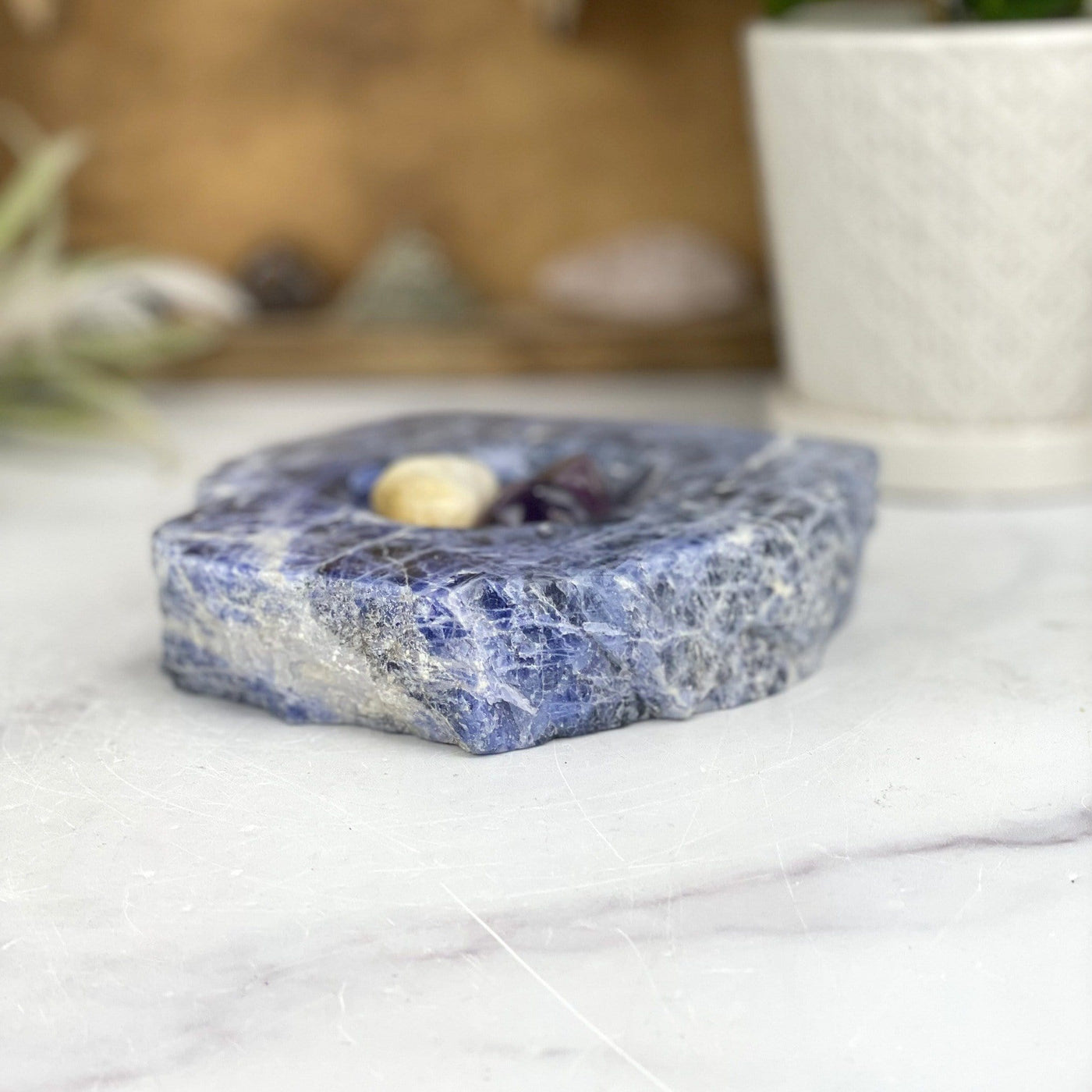 angled view of sodalite polished soap dish laying flat with stones inside for thickness
