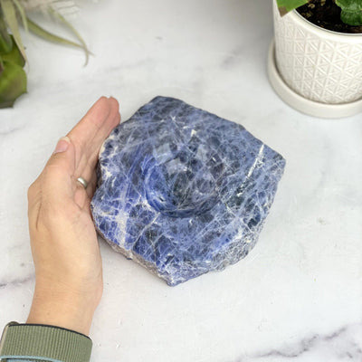 overhead view of sodalite polished soap dish with hand for size reference 