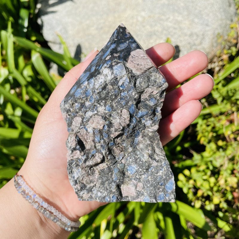 Rhyolite semi polished in woman's hand.  The top is polished to a point rest is left rough.  