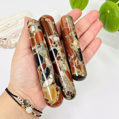 red jasper massage wands in hand showing the different sizes 
