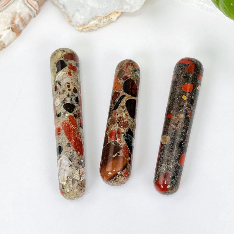close up of the red jasper massage wands showing the different colors in the stone. it has pops of reds, tans, black and browns.