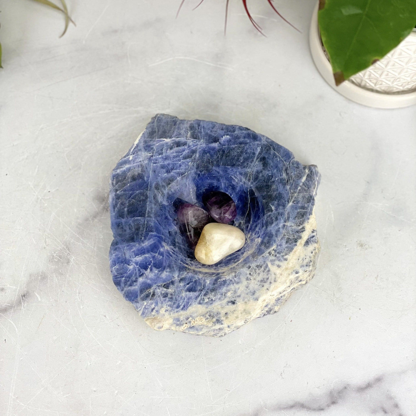 overhead view of sodalite polished soap dish with three stones inside for size reference