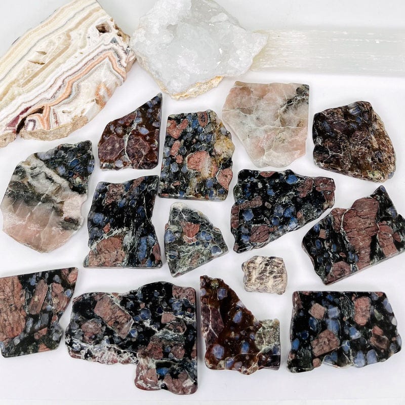 rhyolite semi-tumbled stone slabs on white background displaying the different size variations available in the one pound bag