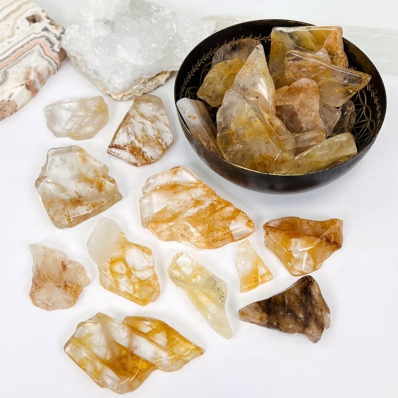 golden healer stone semi polished slabs in a bowl and on a white table top used as home decor 