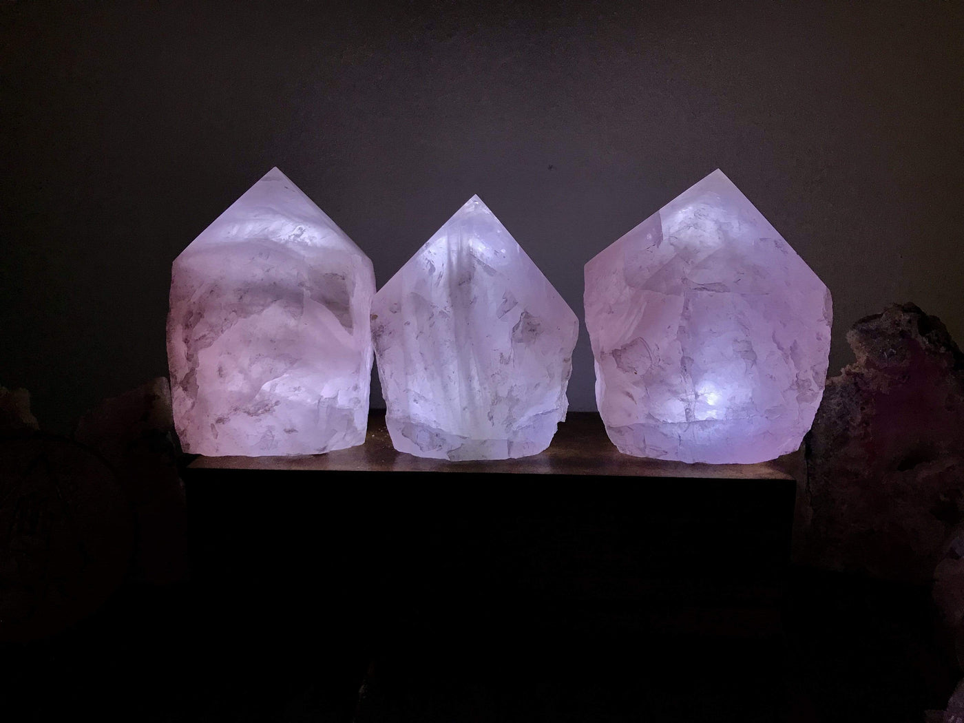 3 Rose Qartz Lamps lit up in a dark room