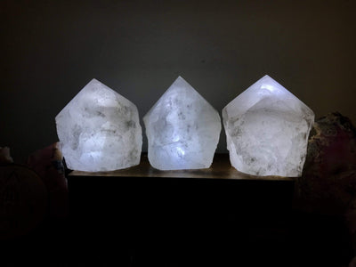 3 Crystal quartz lamps lit up in a dark room