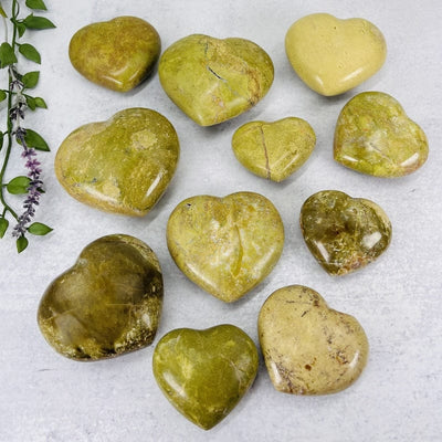multiple green/pistachio opal polished hearts displaying the different sizes and colors patters 