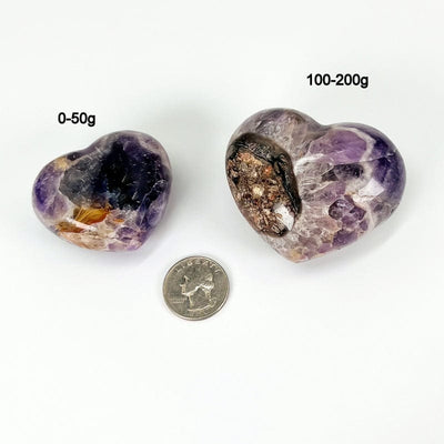 close up of chevron amethyst hearts next to a quarter for size reference and the weight in grams  