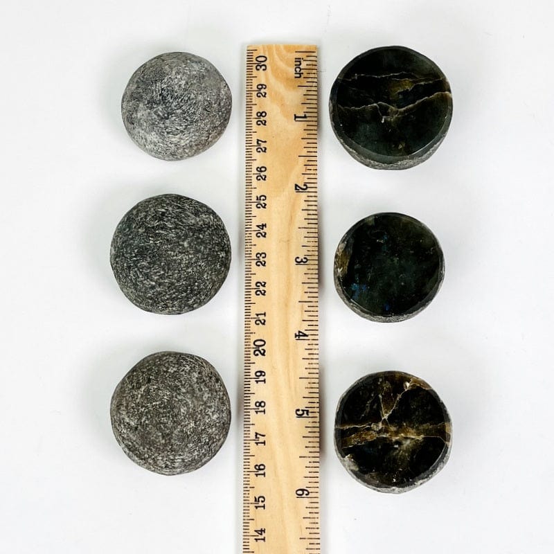 labradorite stones next to a ruler for size reference 