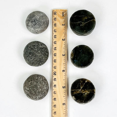 labradorite stones next to a ruler for size reference 