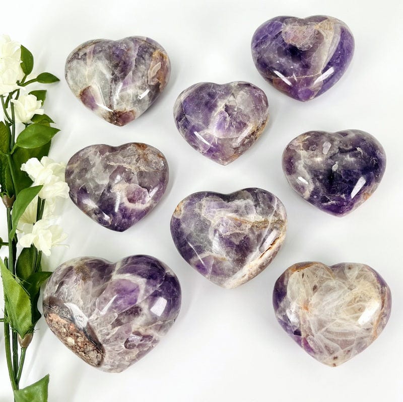 multiple chevron amethyst heart shaped stones displayed showing the different purple and white patterns within the stone 