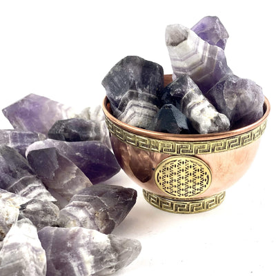 chevron amethyst assorted points on a white background.  Some are in a small copper bowl for display only