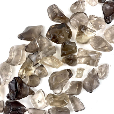 Smokey Quartz Small Tumbled Stones spread out on a table