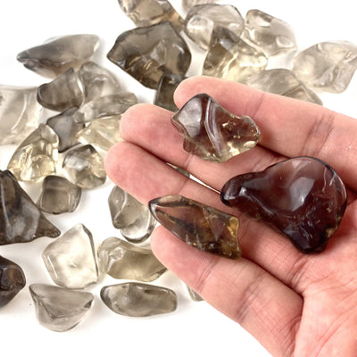 Smokey Quartz Small Tumbled Stones in a hand for size reference