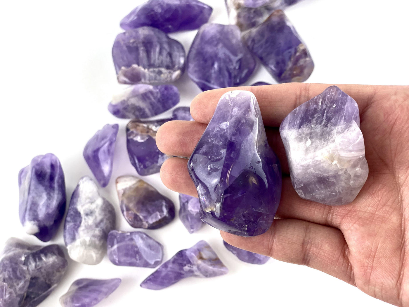 Amethyst Tumbled Stones in hand for size comparison