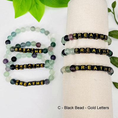 fluorite bracelet with black beads and gold letters that spell out breathe 