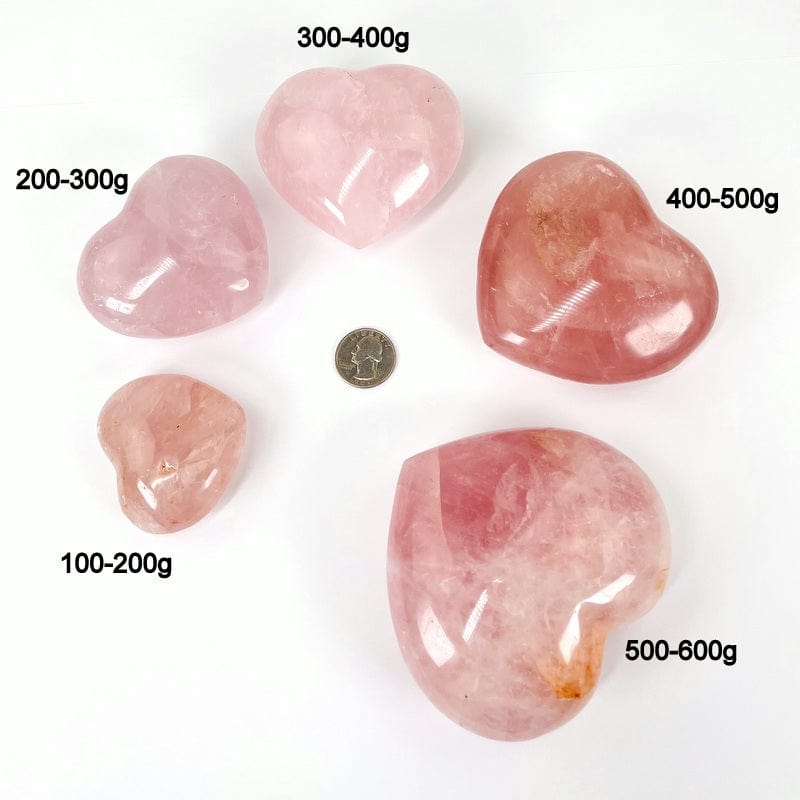 close up of rose quartz puff hearts next to a quarter for size reference and the weight in grams 