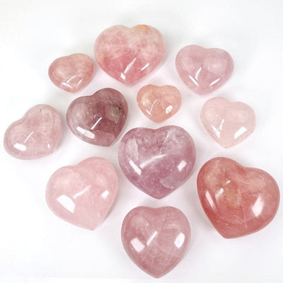 multiple rose quartz puff hearts on a white background displaying the different sizes and variations of pinks 