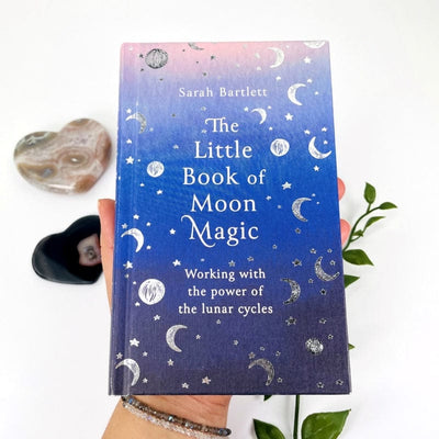 close up of the front of the book titled the little book of moon magic by sarah bartlett 