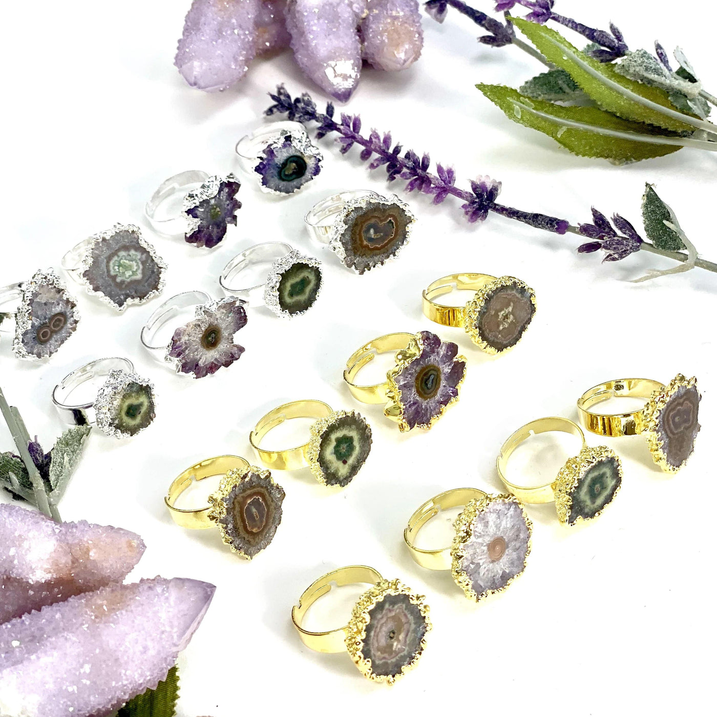 angled shot of 8 silver amethyst stalactite rings and 8 gold amethyst stalactite rings with decorations