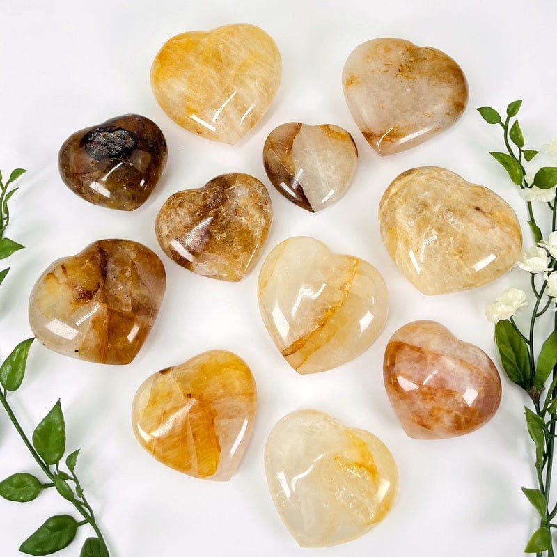 multiple golden healer puff hearts on a white background displaying the different sizes available 