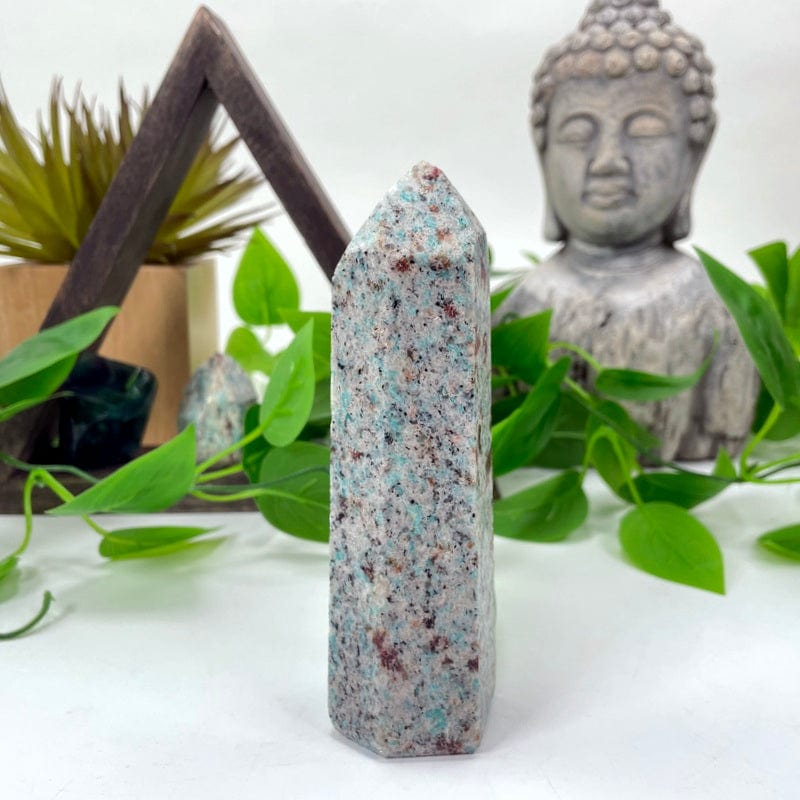 another angle of amazonite polished point in front of backdrop