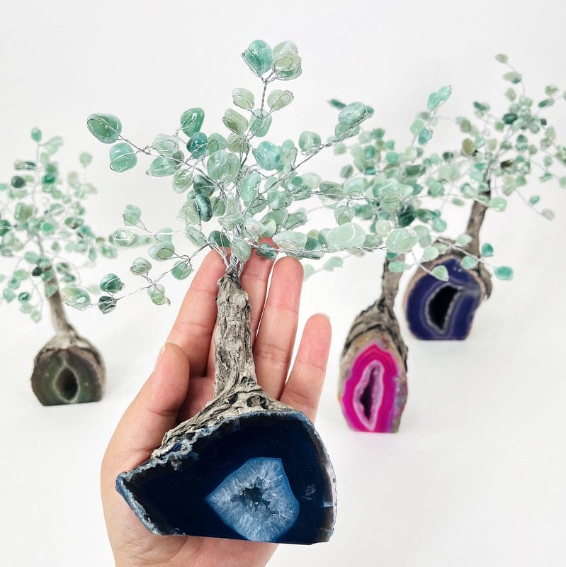 geode tree with tumbled green quartz in hand displaying size