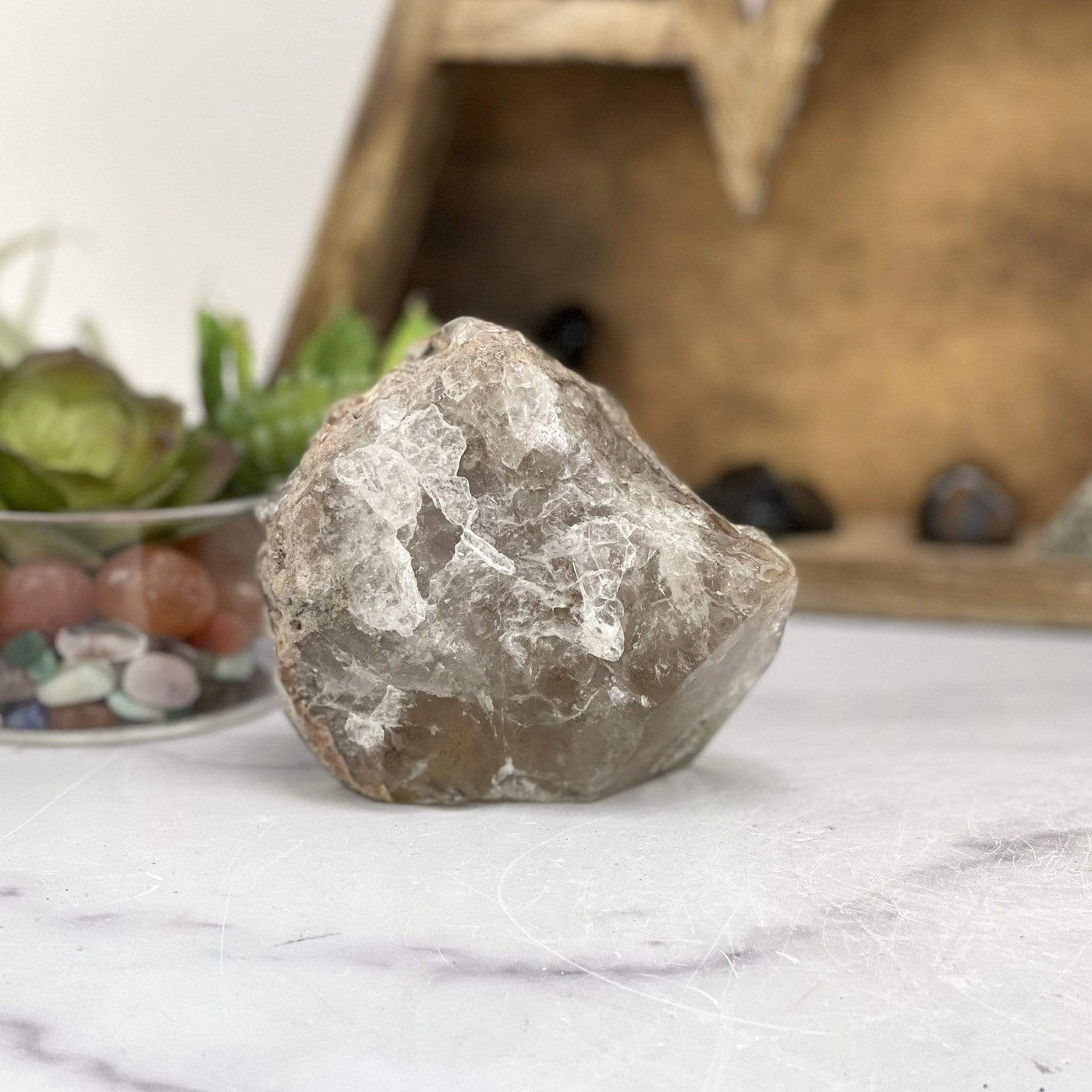 smokey quartz lodalite stone on a gray marble background.