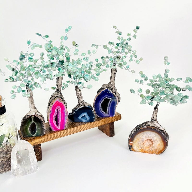 multiple colored geode trees with green quartz tumbled stones on the top portion 