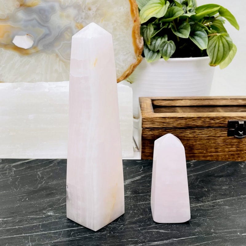 two pink calcite obelisk next to each other showing the size difference 