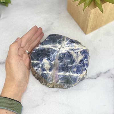 overhead view of sodalite polished soap dish with hand for size reference