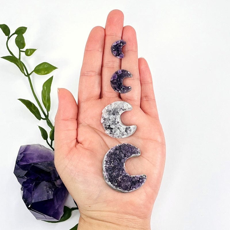 amethyst shaped as moon crescents in hand for size reference 