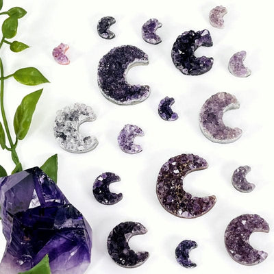 multiple amethyst drusy stones shaped as moon crescents displayed to show the differences in the size variations 