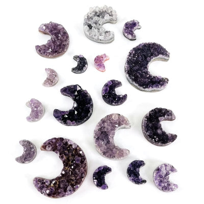 multiple amethyst drusy stones shaped as moon crescents displayed to show the different shades of purples, pinks and even some whites