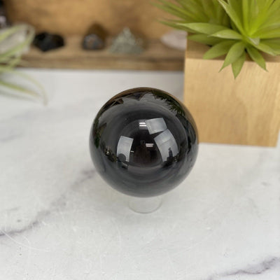 Black Obsidian Sphere with decorations in the background
