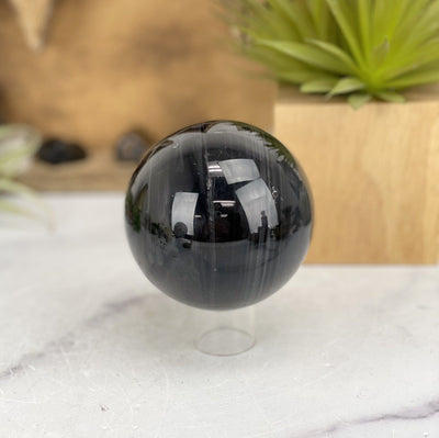 Black Obsidian Sphere with decorations in the background