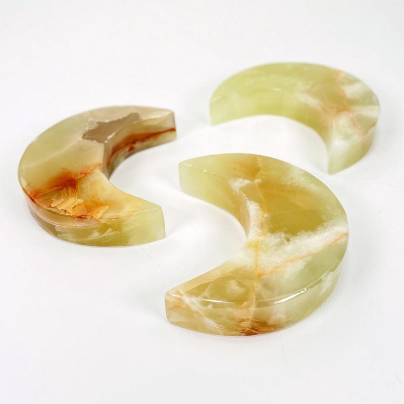 3 green onyx moons on a table