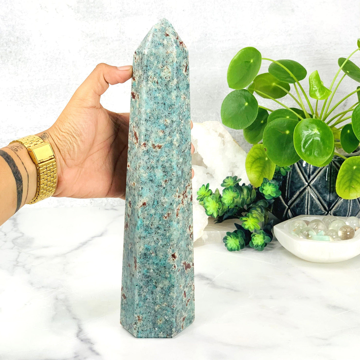 Hand comparing size to the Amazonite Polished Point Tower 