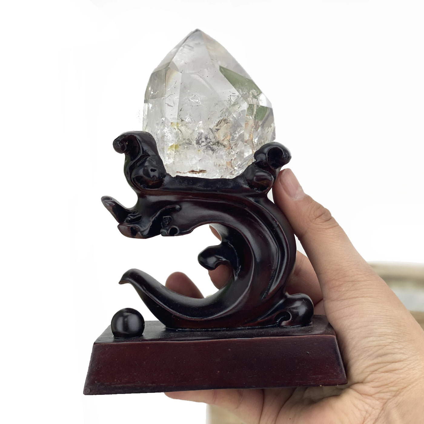 Lodolite Crystal Quartz Enhydro on Wooden Stand held in hand.