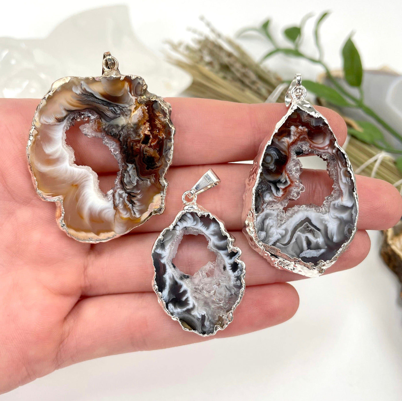 three agate druzy slice pendants in hand for size reference and possible variations