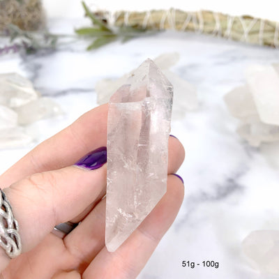 51gram - 100 gram lemurian quartz in hand with marble background