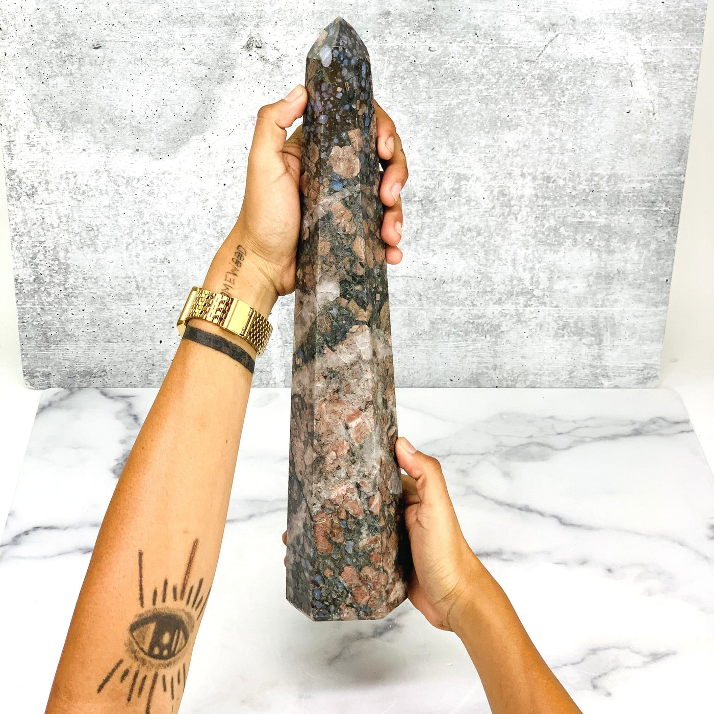 Two hands holding the Large Rhyolite Polished Point