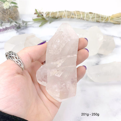 201gram - 250 gram lemurian quartz in hand with marble background