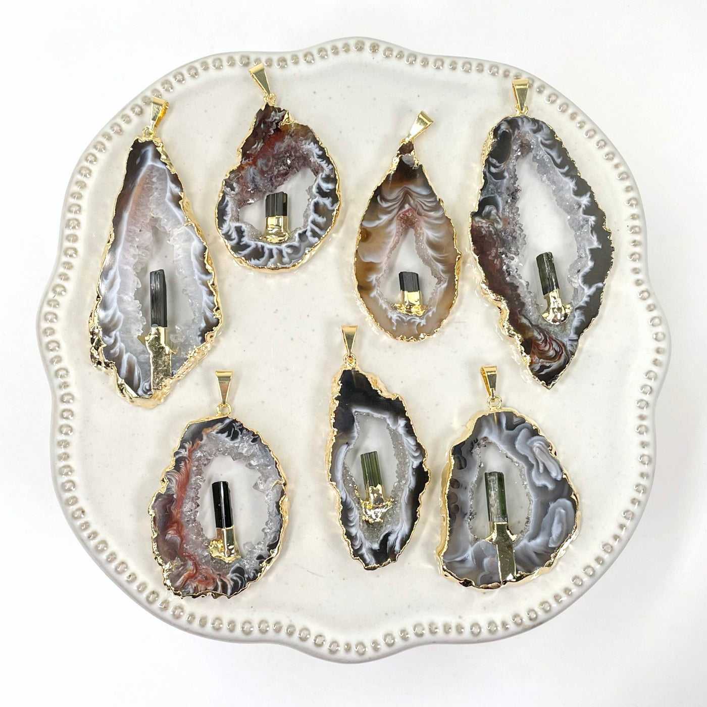 overhead view of many agate druzy slice pendants on display for possible variations