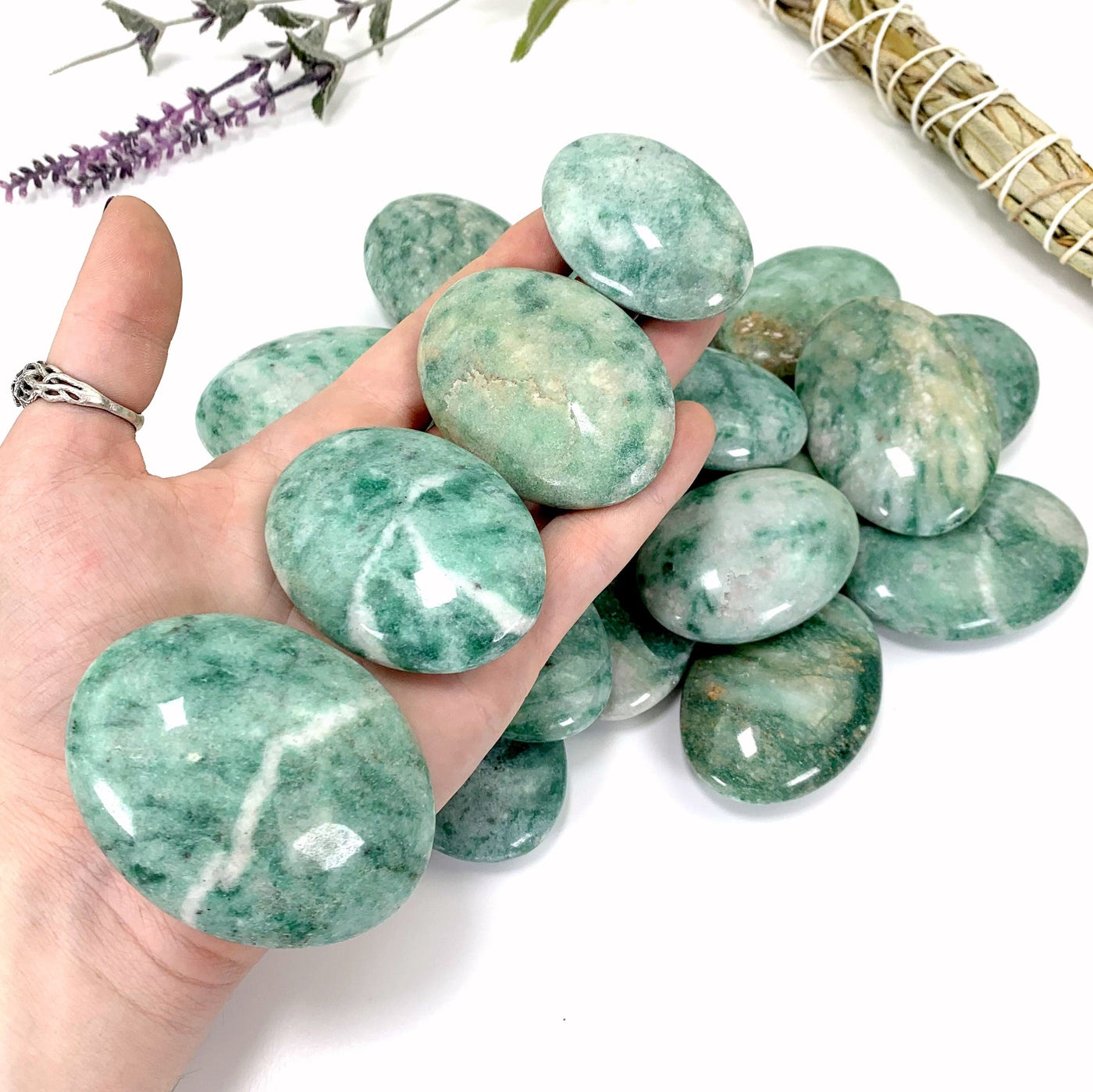 4 palm stones in hand with white background