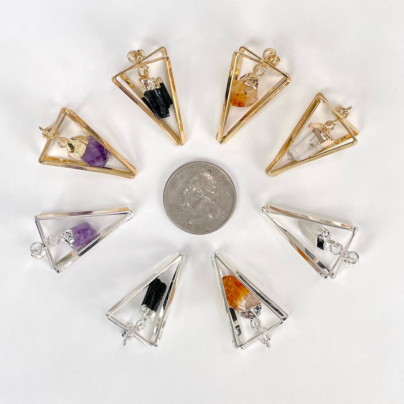 one of each dangle stone point pendulum pendant options surrounding a quarter on white background for size reference